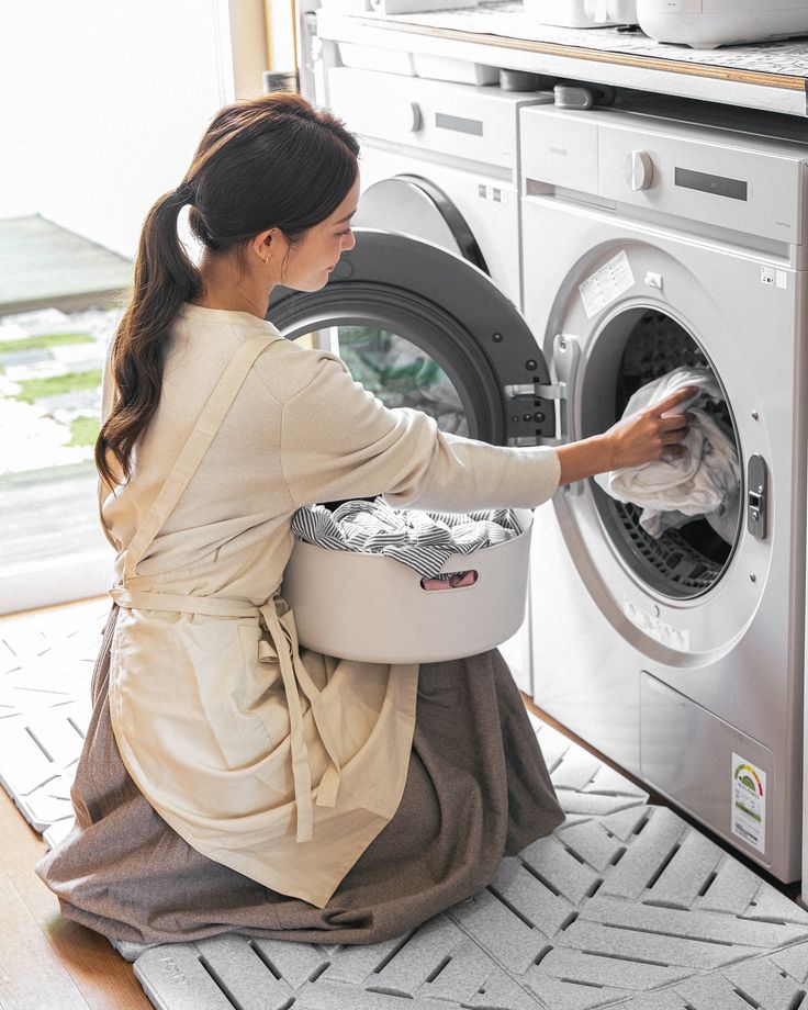 Housemaid performing household tasks including tidying and laundry